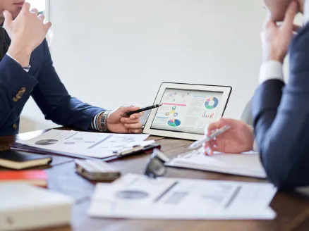 タブレットに表示されたデータを基に二人の職員が会議している様子